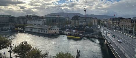 A river with a bridge, buildings, and a statue.