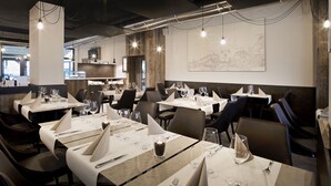 A modern restaurant interior with neatly arranged tables, chairs, and a large map on the wall.
