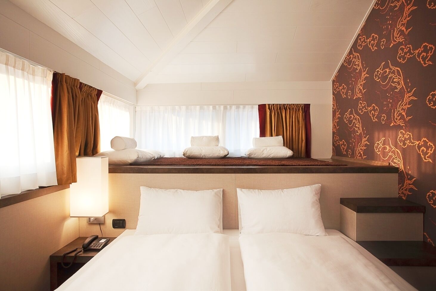 Ein Hotelzimmer mit Bett, Nachttischen, einer Lampe und einem Telefon.