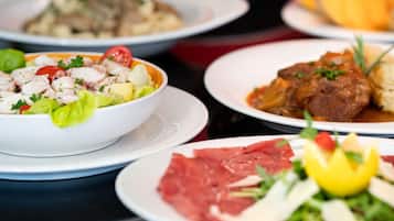 Variedad de platillos en una mesa, como ensalada, carne y sopa.