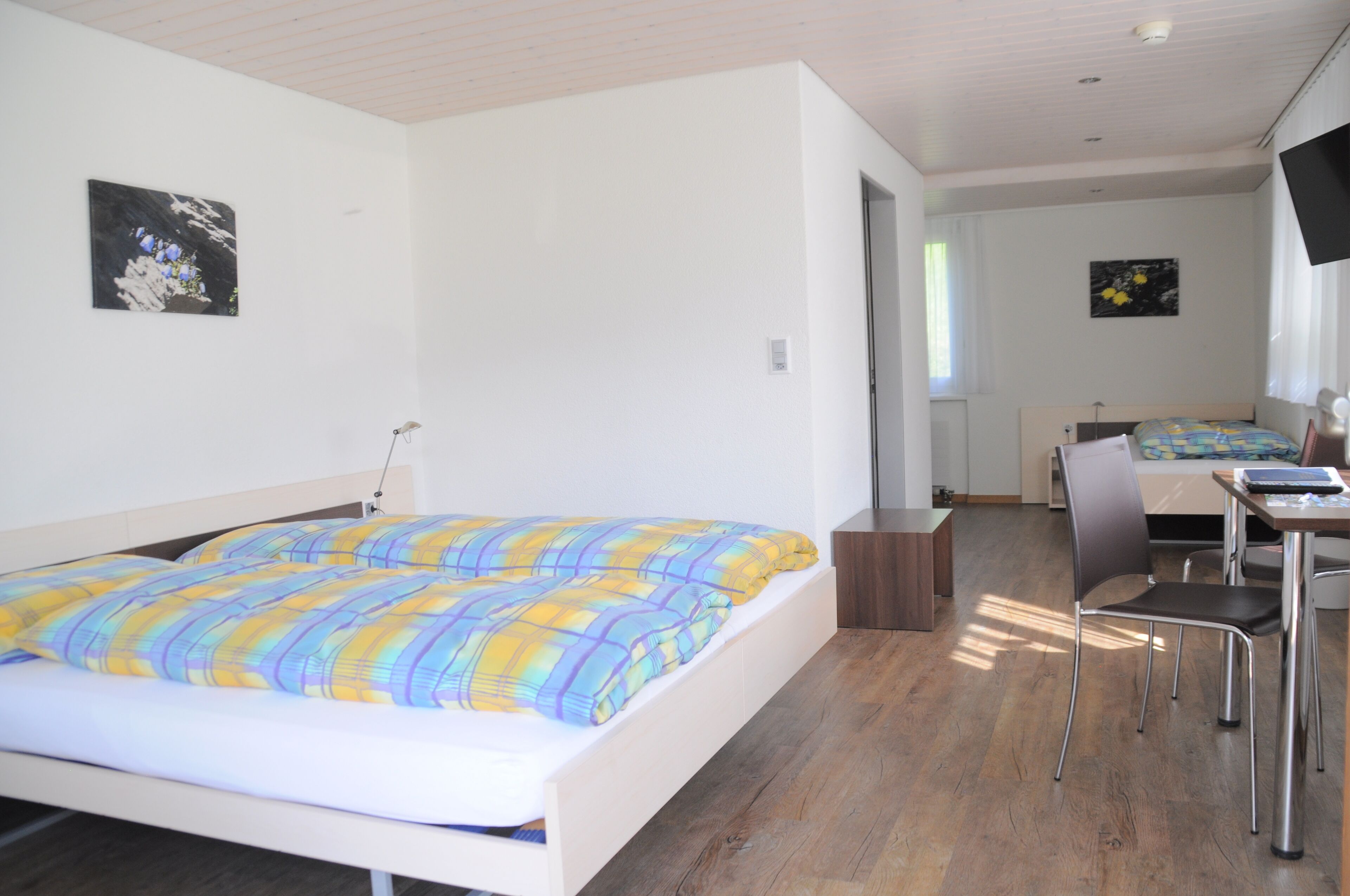 Un dormitorio moderno con una cama, un escritorio y una silla.