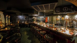 A bar area with stools, a bar counter, and various bottles and glasses. - Albergo Losone (Losone)