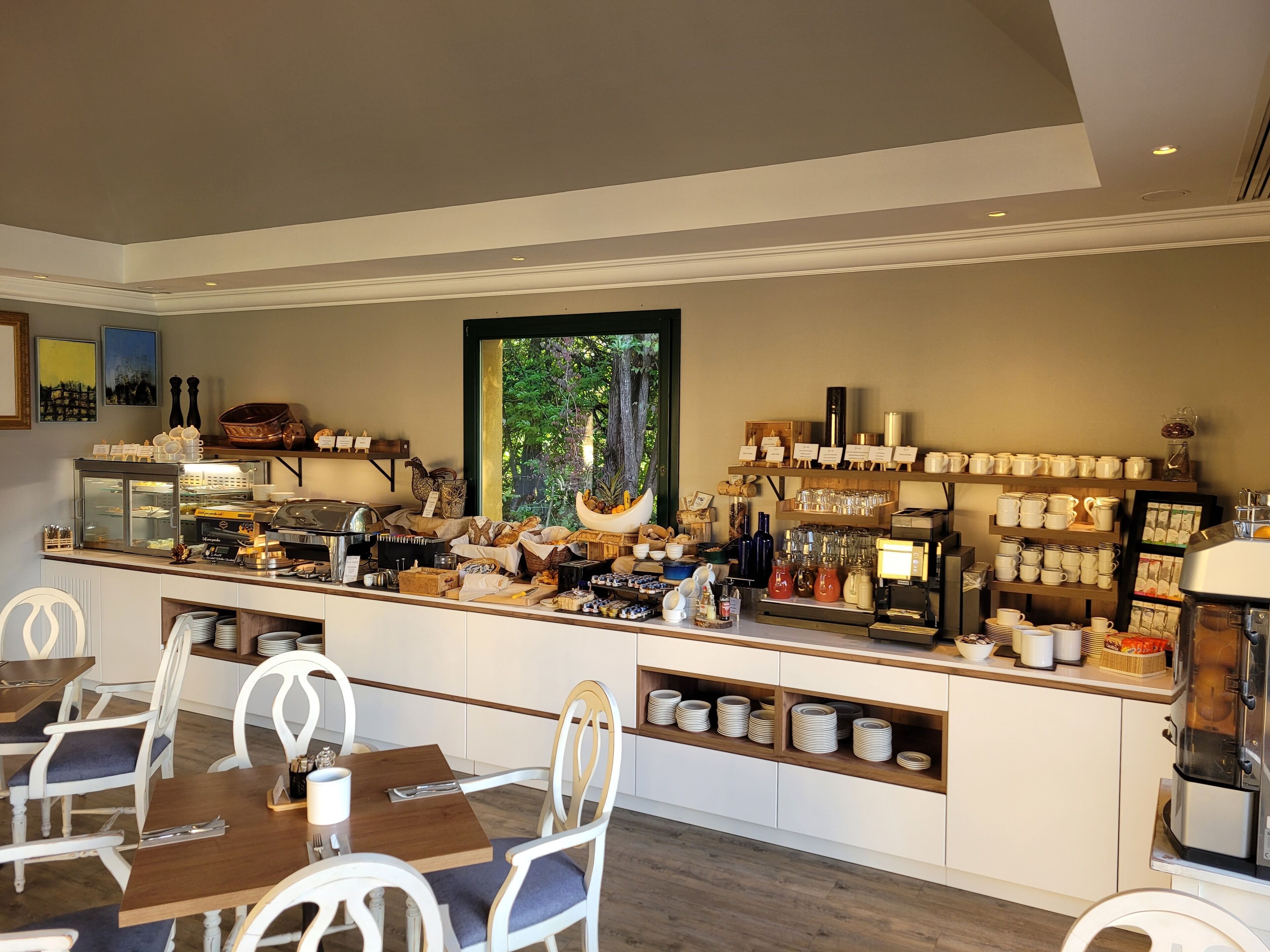 A breakfast bar with seating, a coffee machine, and various food items.