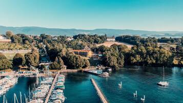 A marina with numerous boats docked, surrounded by lush greenery and hills in the background.