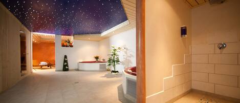 Um interior moderno com teto estrelado, área de estar central e uma escadaria.