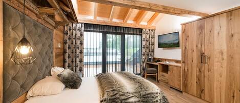 A bedroom with a bed, a desk, and a wardrobe.
