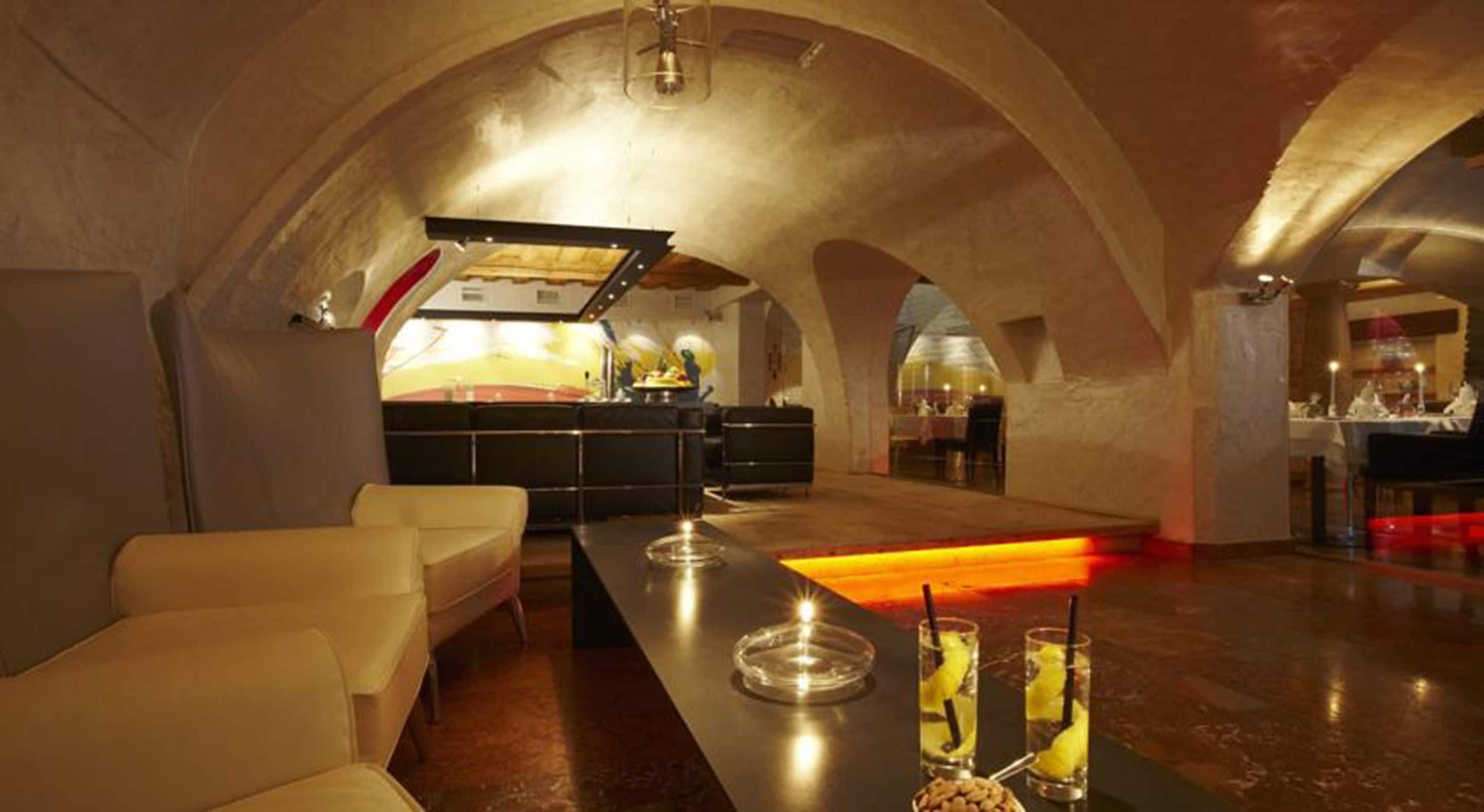 Un intérieur spacieux avec un long comptoir-bar, des places assises et une cuisine située au fond de la pièce.