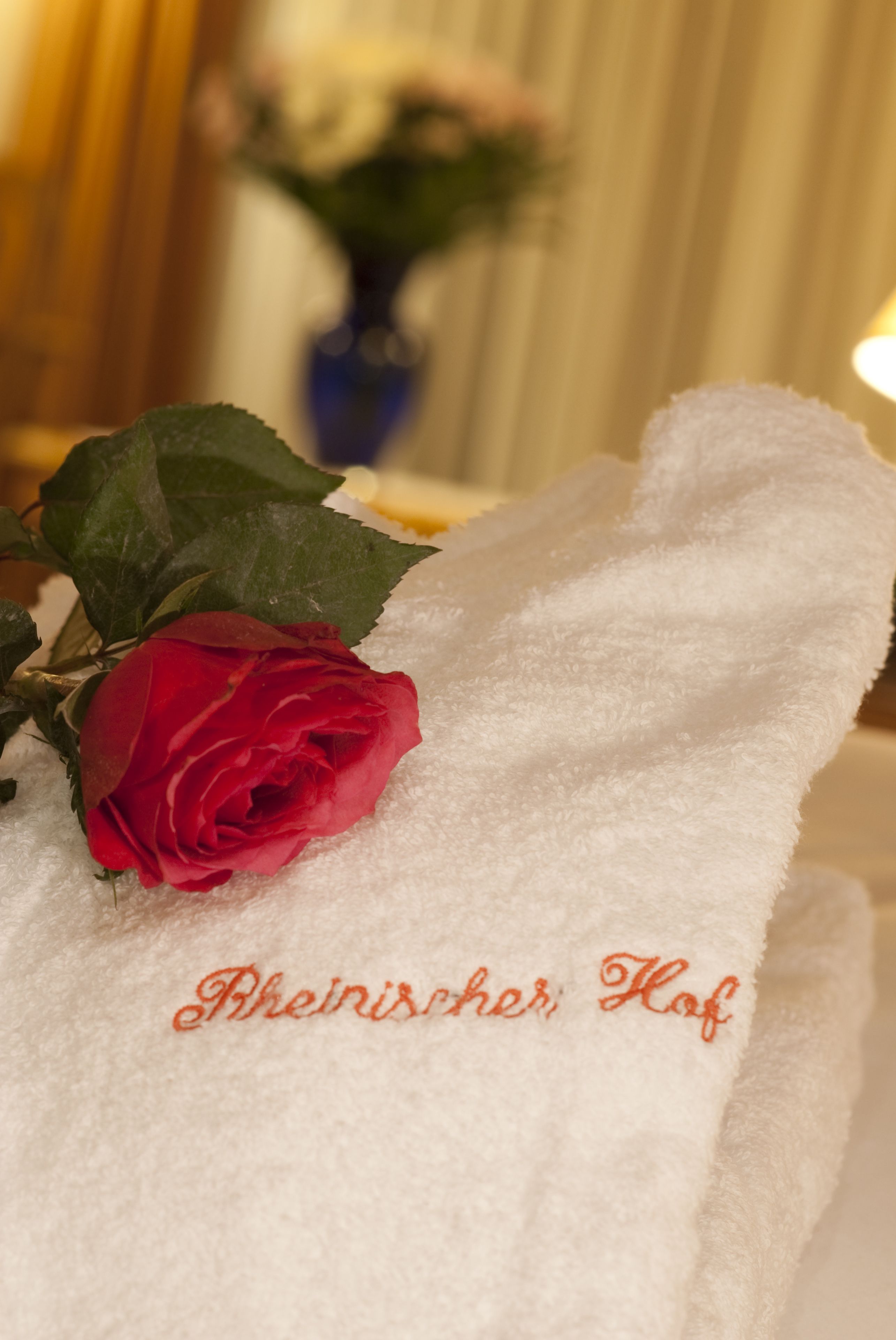 A white towel with embroidered text and a red rose.