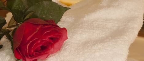 A white towel with embroidered text and a red rose.