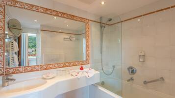 Un baño con un espejo grande, un lavamanos, ducha y bañera.