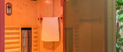 A physiotherapy room with a wooden interior, a towel rack, and a table with candles.