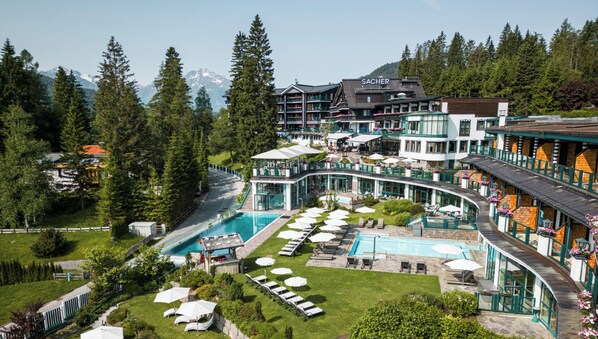 A hotel with a pool, outdoor seating, and mountain views. - Alpin Resort Sacher (Seefeld in Tirol)