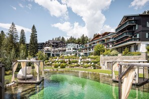 A resort with a clear pool, outdoor seating, and multiple-story buildings with balconies. - Alpin Resort Sacher (Seefeld in Tirol)