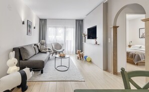 Suite junior, balcón | Área de sala de estar | Televisión de pantalla plana y juguetes 