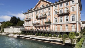 A multi-story hotel with balconies and a riverside location.