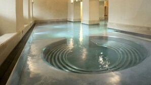 A spacious indoor area with a large, circular water feature in the center.