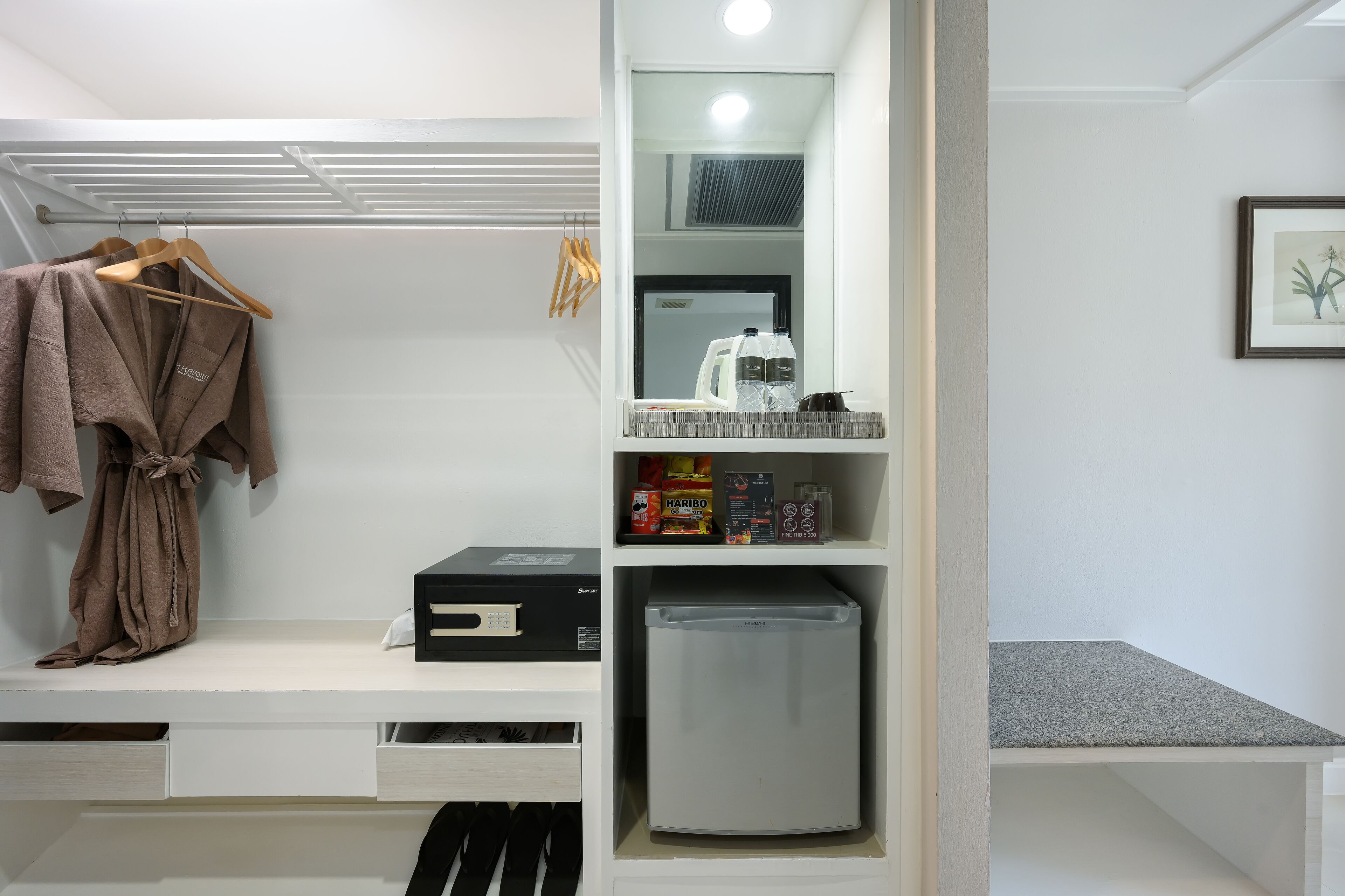 A modern bathroom with a built-in shower, a towel rack, a mirror, and a shelf with toiletries.