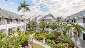 A resort with white buildings, a central garden, and a pathway.