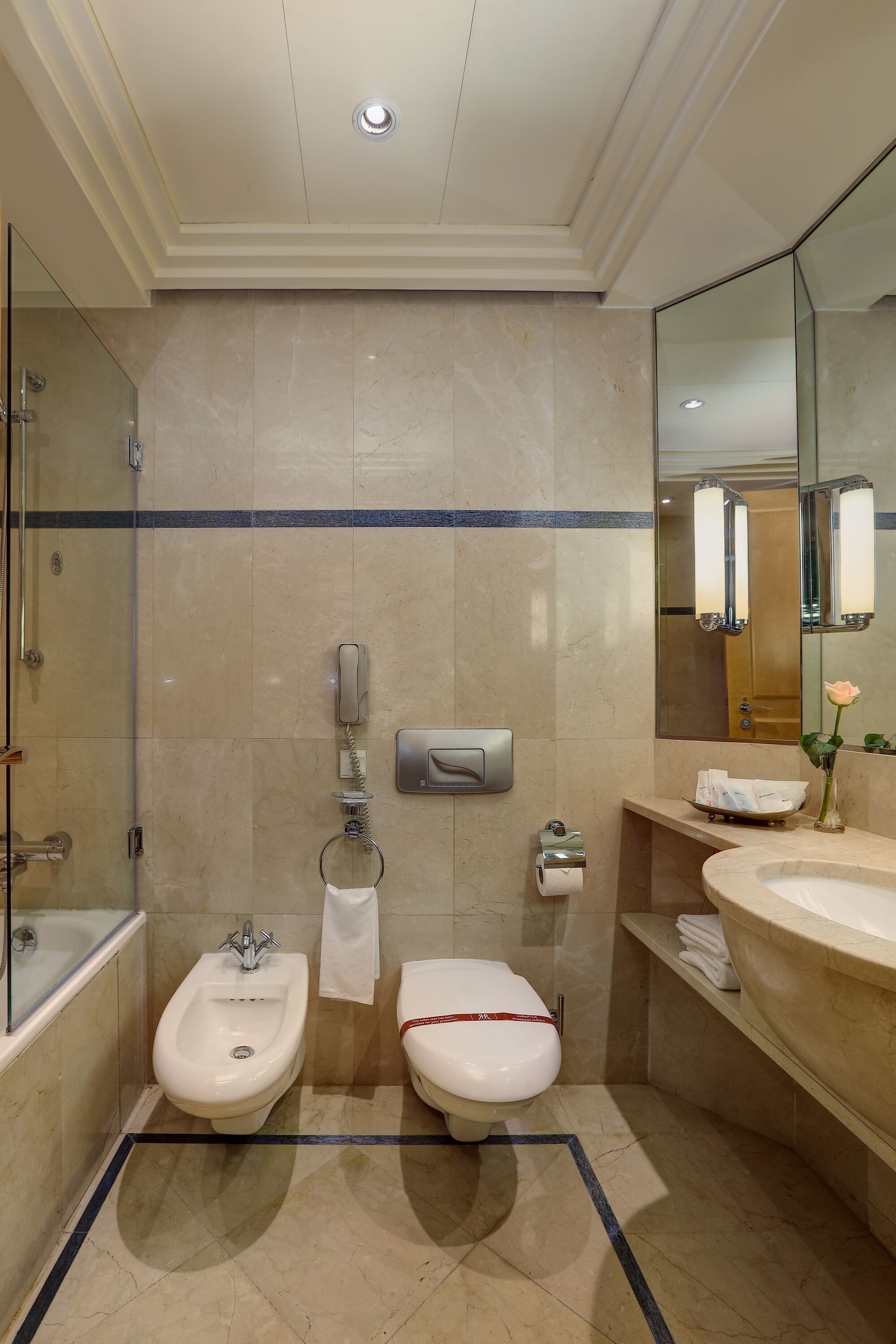 A modern bathroom with a bidet, toilet, and large sink.