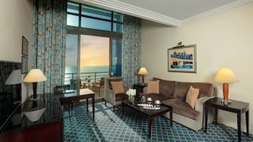 Ein Hotelzimmer mit großem Fenster, einer Couch, einem Couchtisch und zwei Lampen.