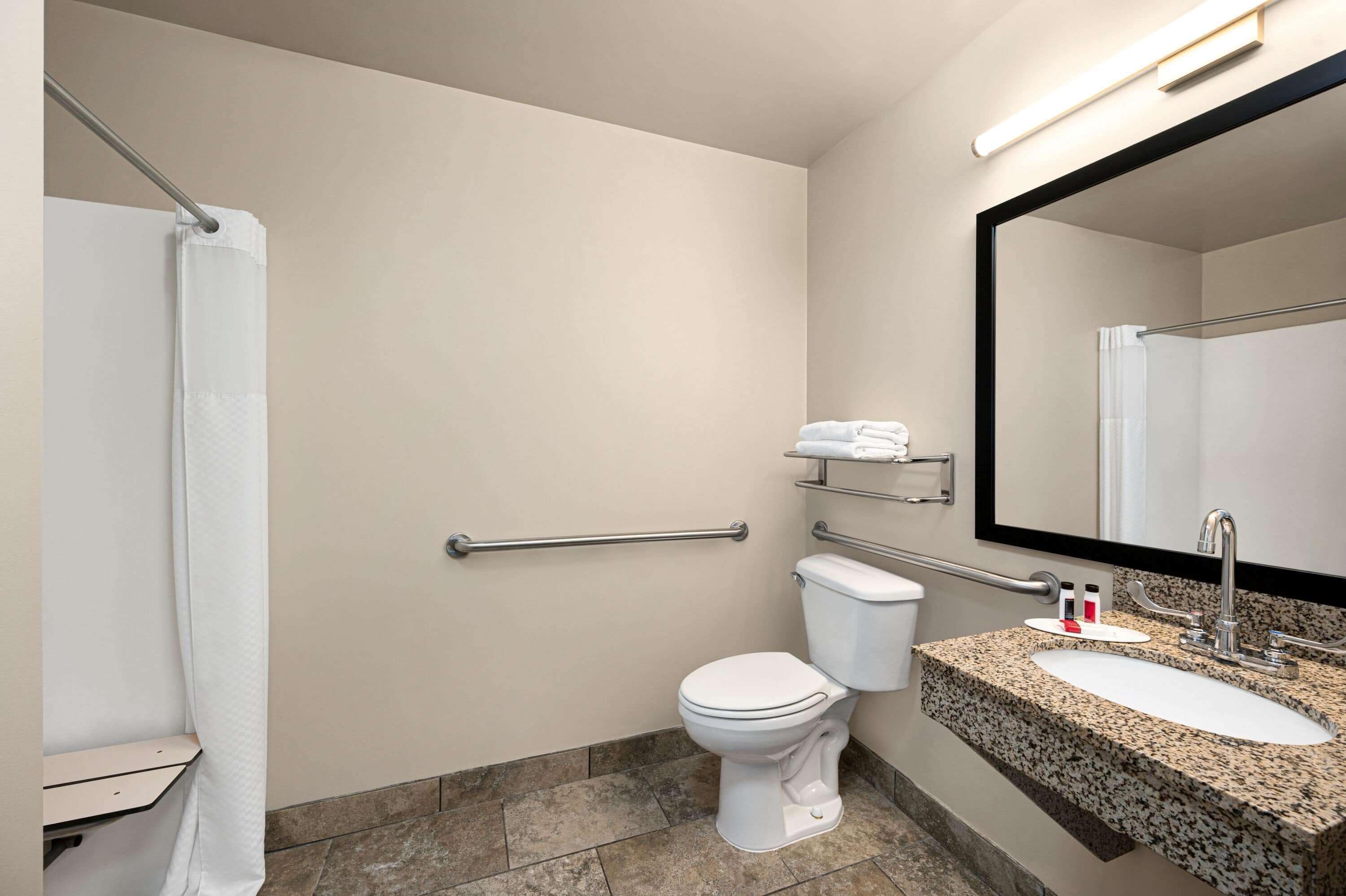 Een moderne badkamer met toilet, wastafel en douche.
