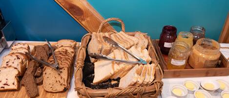 A variety of breads and jams on a table.
