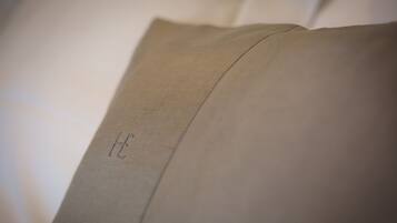 Primer plano de una almohada con una letra 'H' bordada a la vista.
