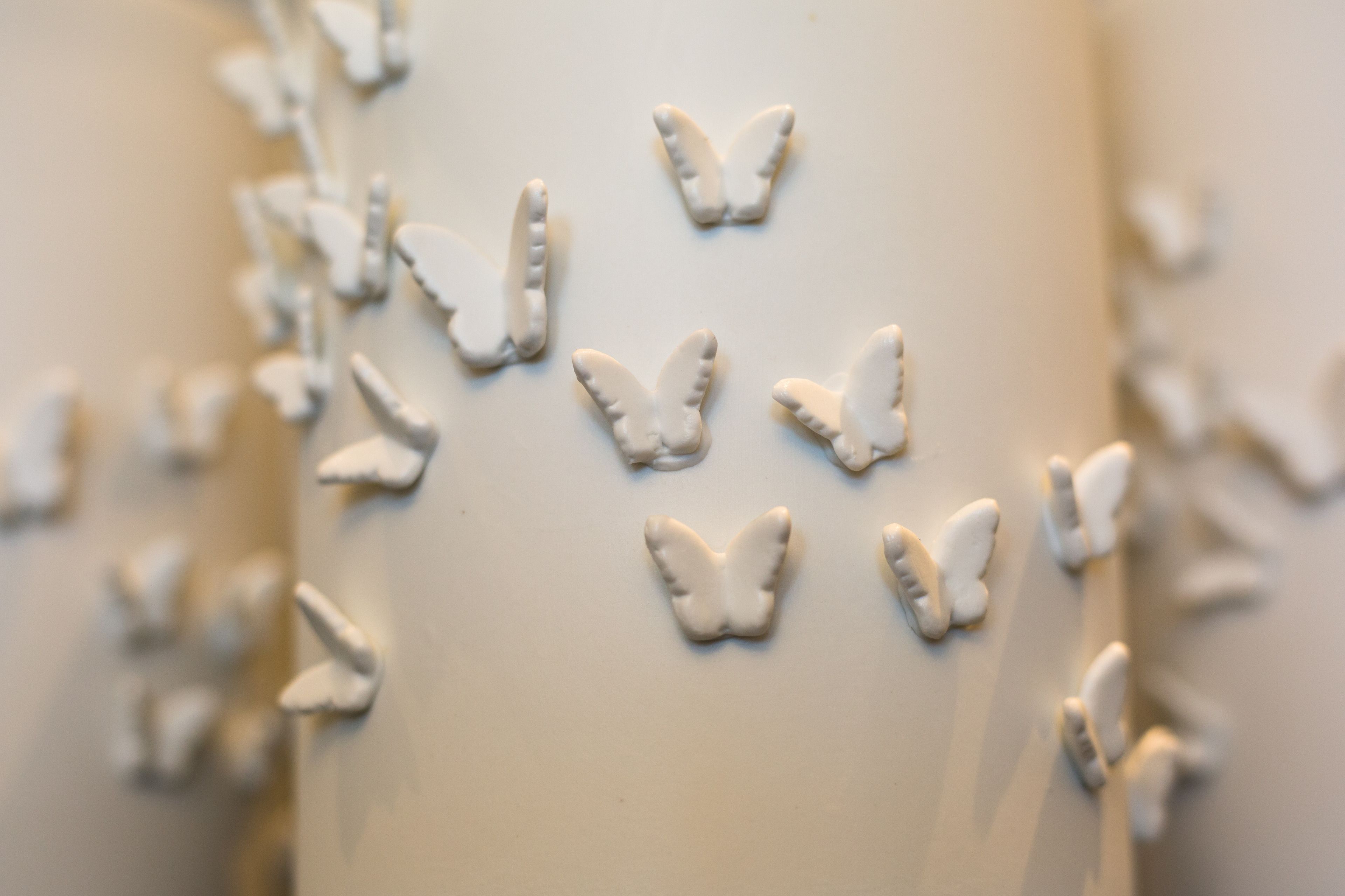 Un mur décoré de nombreux motifs de papillons blancs.
