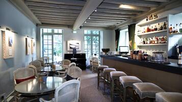 A bar area with a piano, seating, and a bar stocked with various bottles.