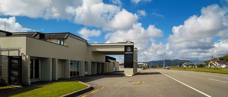 A modern building with a clear sky and clouds. There is a sign for the Ashley Hotel.
