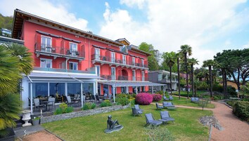 Un edificio rojo con terraza al aire libre y jardín.