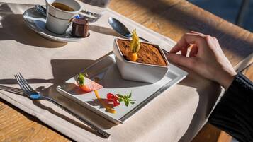 Un plato de postre con un dulce de chocolate, una rebanada de sandía y algunos adornos sobre una mesa.