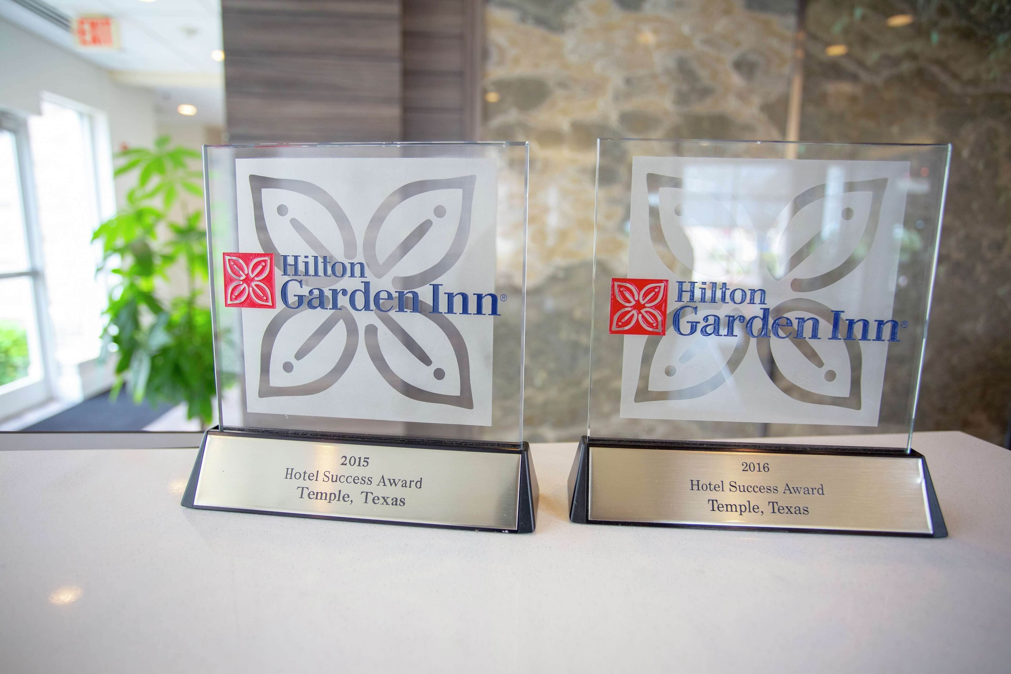 Dos placas de vidrio con el logotipo de Hilton Garden Inn y el texto 'Hotel Success Award Temple, Texas' correspondientes a los años 2015 y 2016.