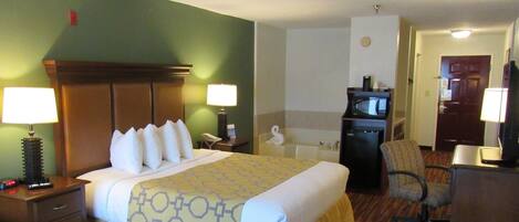 Une chambre d’hôtel équipée d’un lit, de lampes de chevet, d’un bureau avec un ordinateur, d’une chaise, d’un four à micro-ondes et d’un téléphone.
