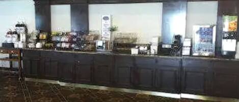 A hotel reception area with a long counter, dark wooden cabinets, and a patterned carpet.