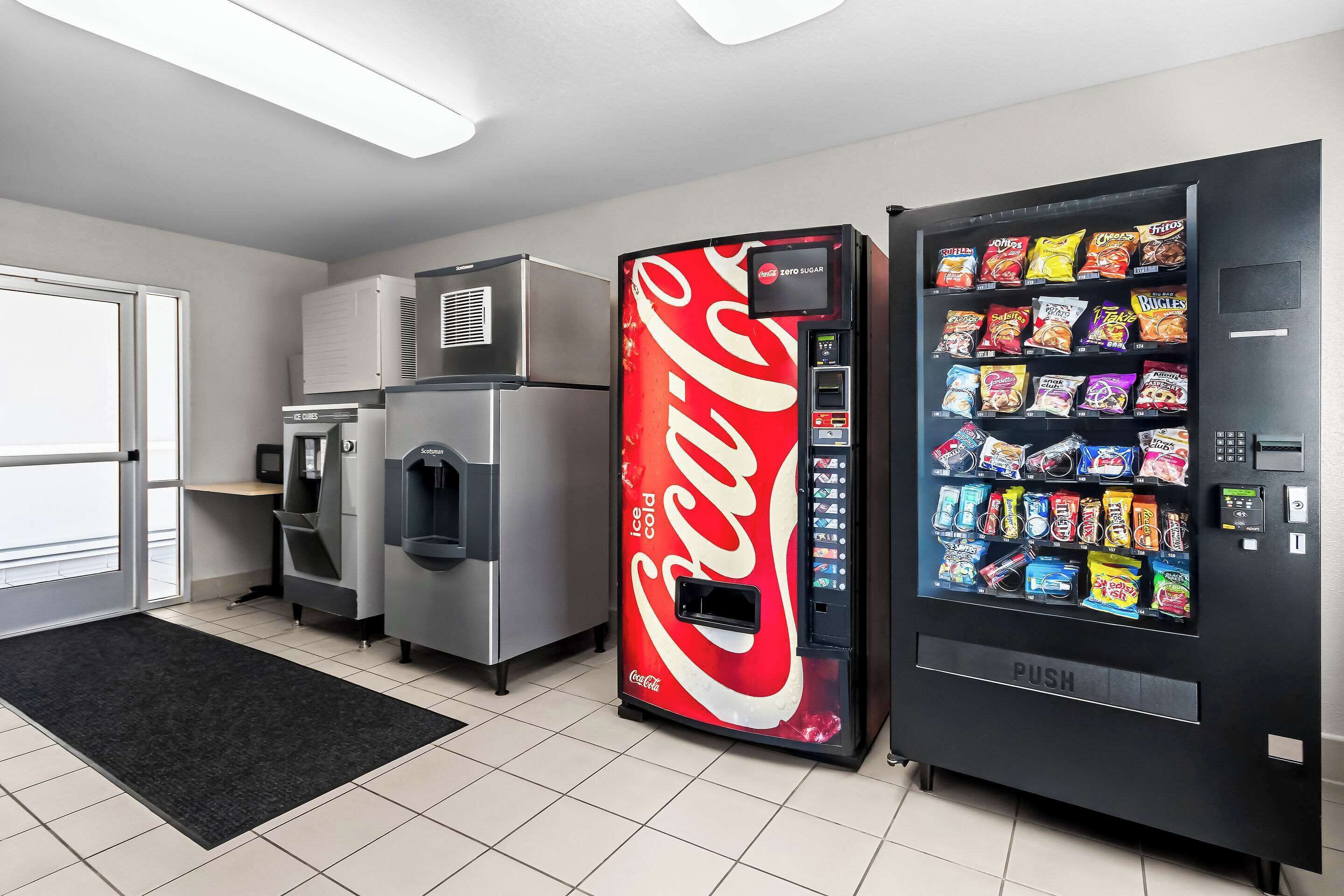 Ein Getränkeautomat mit Coca-Cola-Logo und einem Knopfdruck-Snackspender.