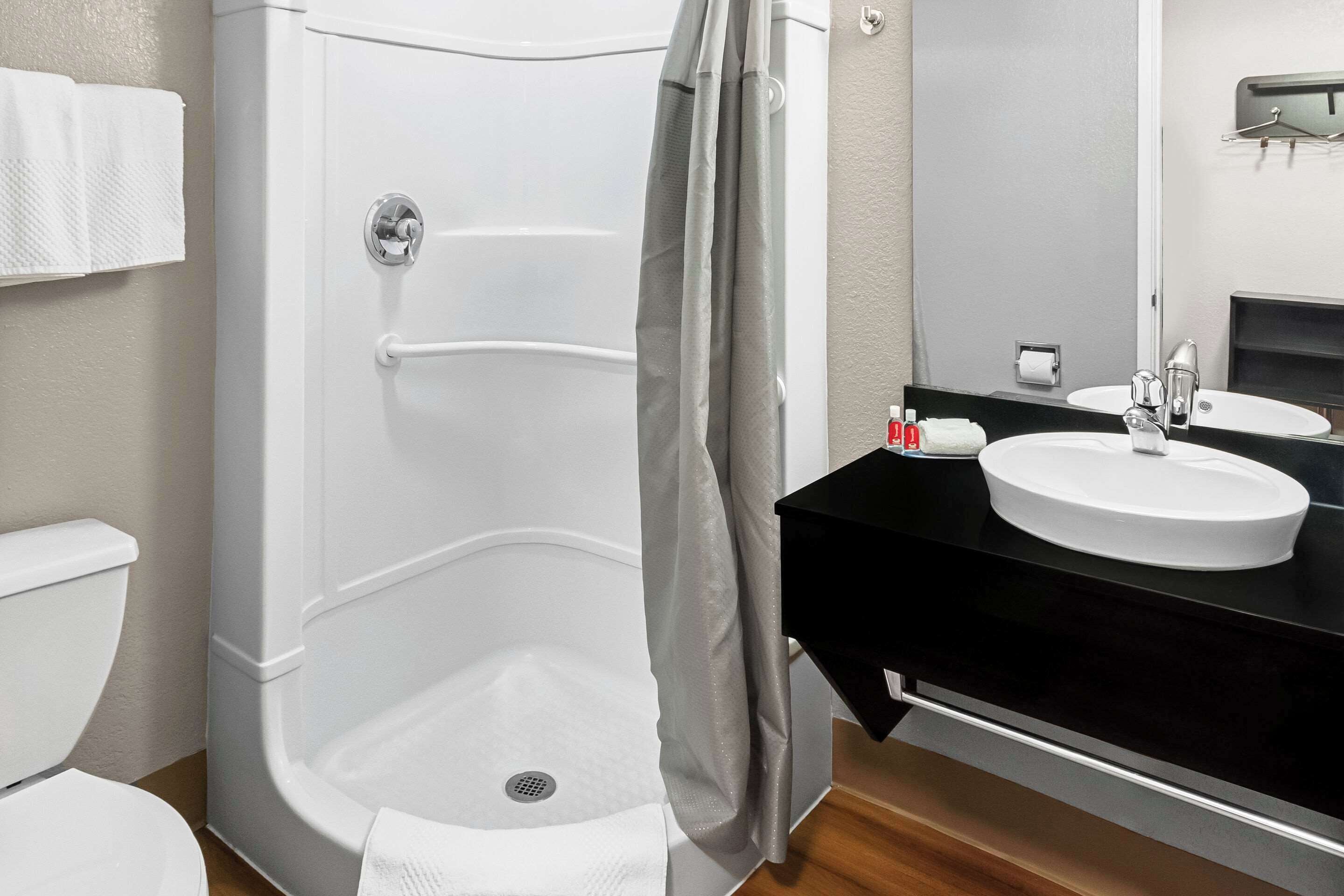 A bathroom with a white bathtub, a sink, and a toilet.