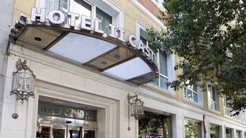 A hotel entrance with a prominent sign, a glass door, and a lamp post.