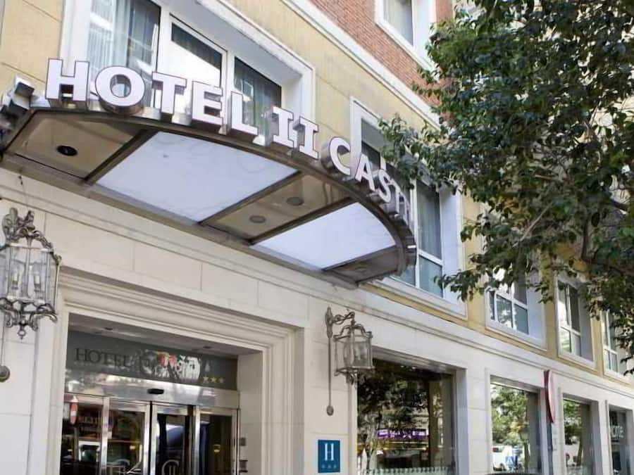 Entrada de hotel con un letrero llamativo, una puerta de cristal y un poste de luz.