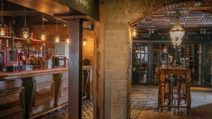 A bar area with wooden bar counters, hanging lights, and a chandelier. - The Roker Hotel, BW Premier Collection (Sunderland)