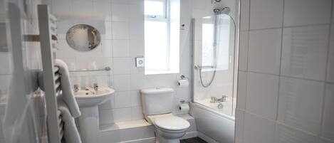 A modern bathroom with a toilet, sink, and shower.