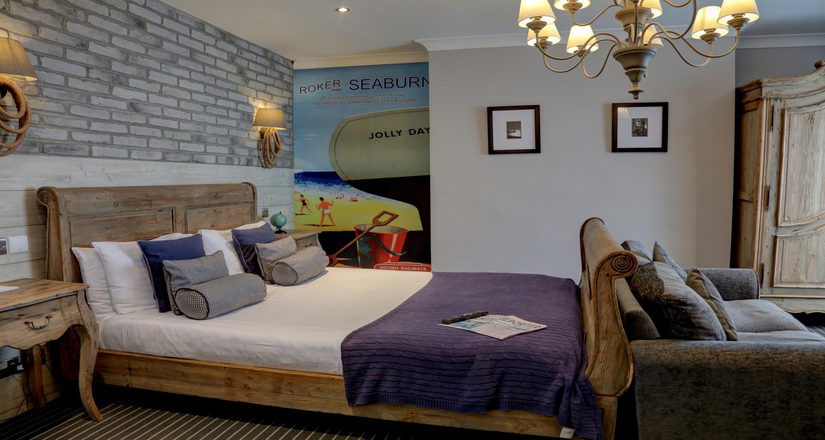 A bedroom with a wooden bed, a globe, a framed picture, a lamp, and a poster on the wall.