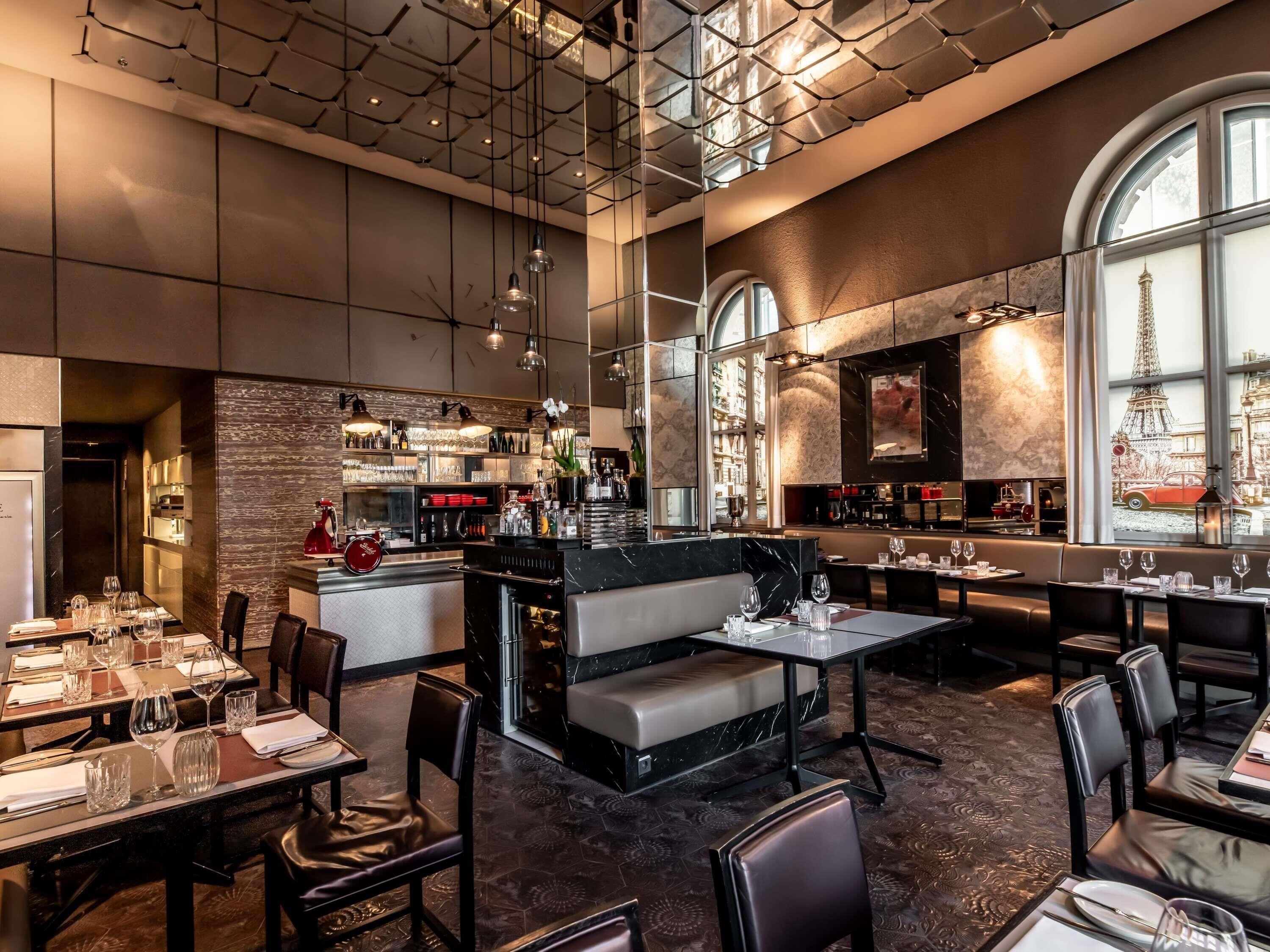 Un ristorante moderno con zona bar, soffitti alti e ampie finestre con vista sulla Torre Eiffel.