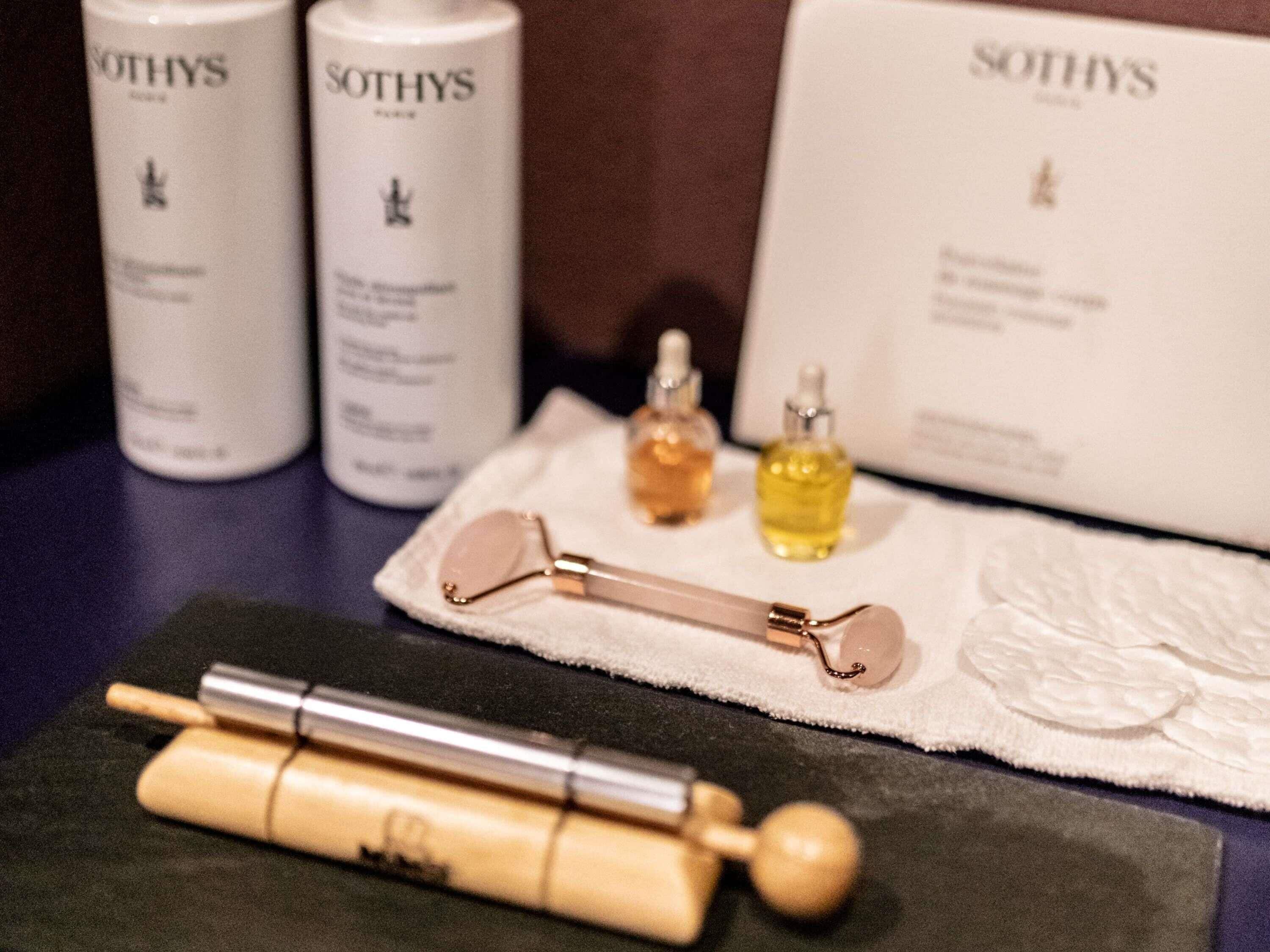 Ein Hautpflege-Set bestehend aus einem Gesichtsmassagegerät, einem Metallmassagegerät und zwei Lotionflaschen, allesamt von Sothys.
