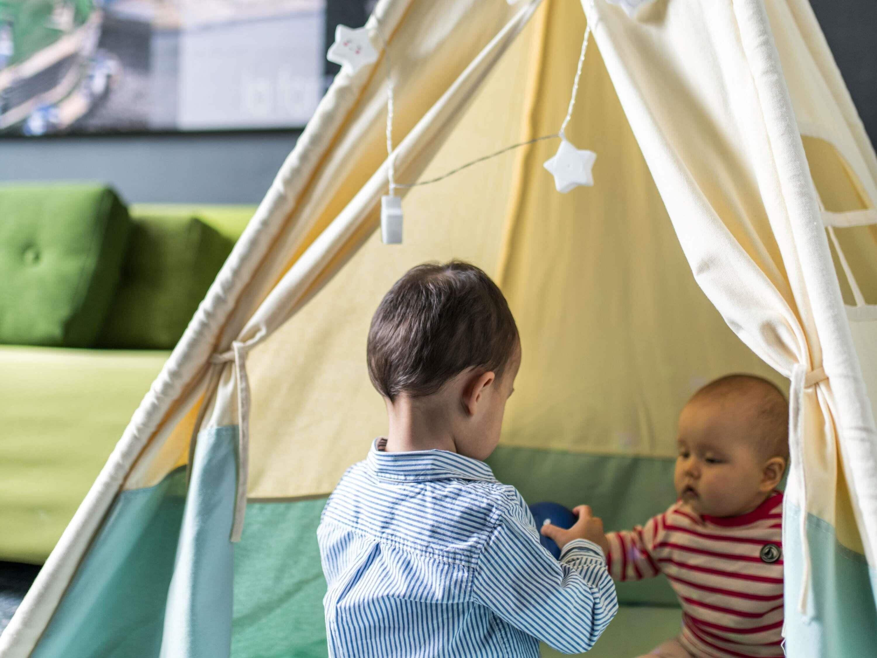 A child and a baby inside a tent-like structure.