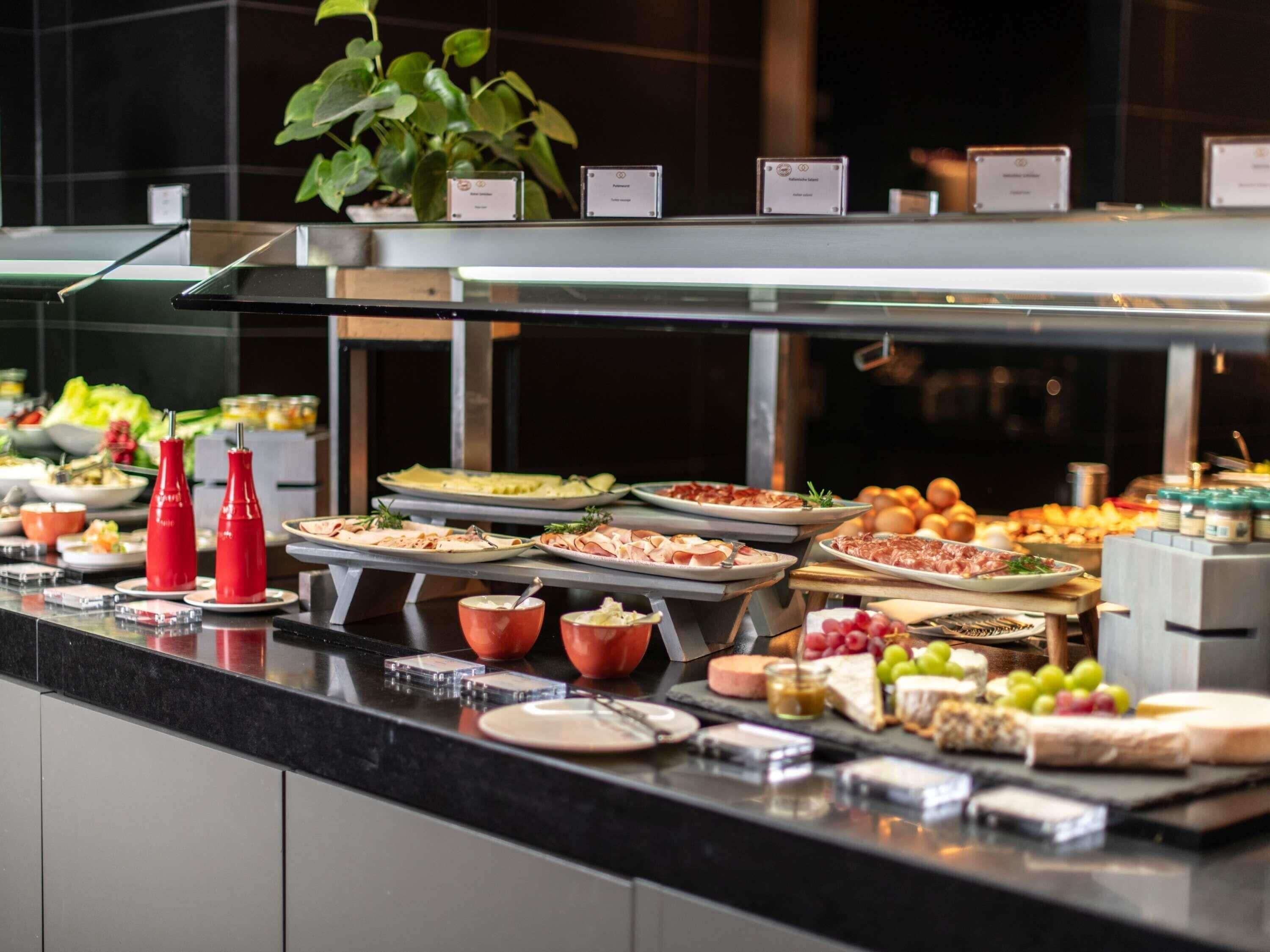 A buffet with various food items and condiments.