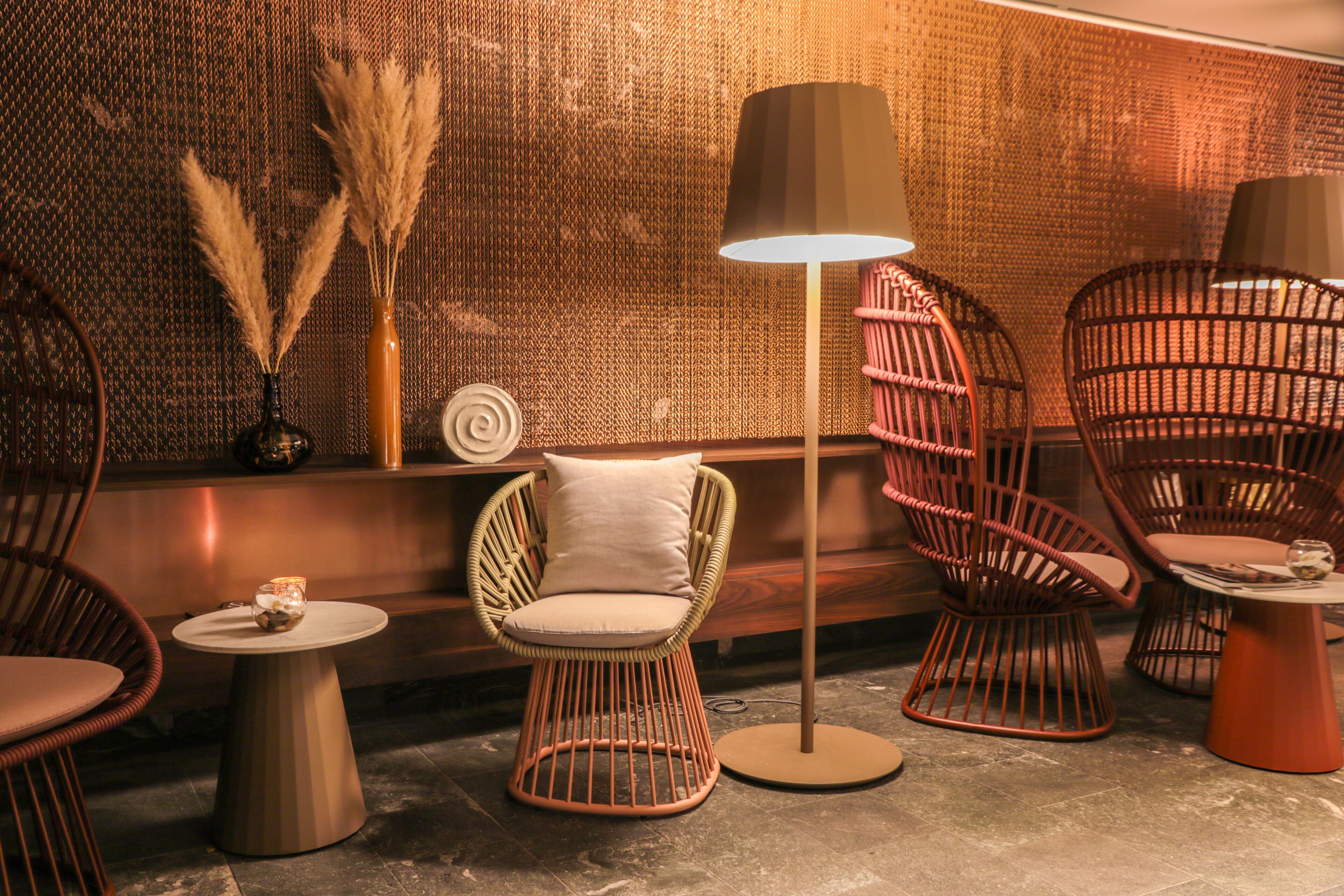 A cozy seating area with wicker chairs and a floor lamp.
