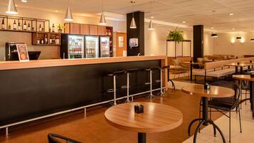 A modern bar area with a counter, stools, and seating.