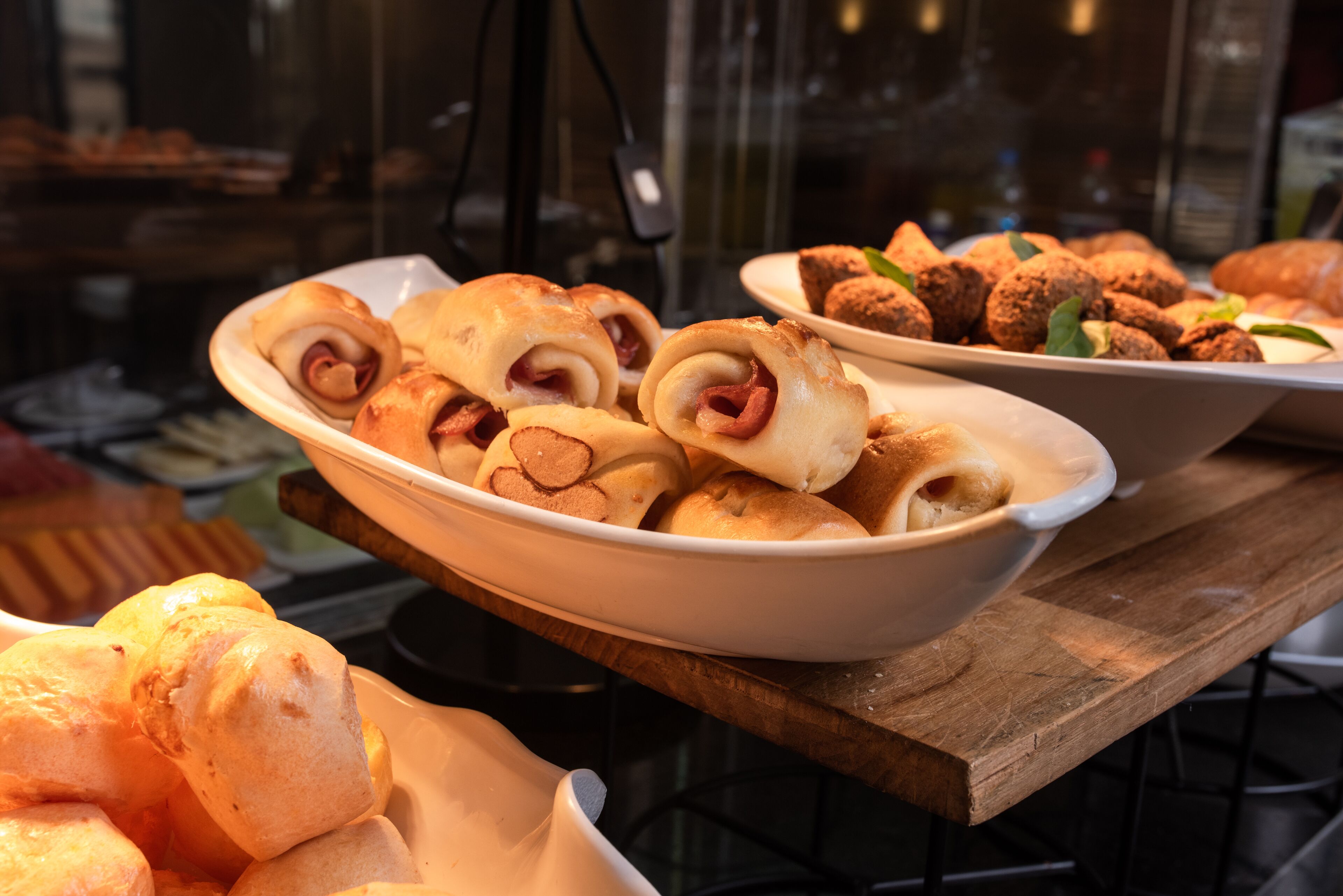 Buffet com diversos produtos de panificação, incluindo pães e doces.