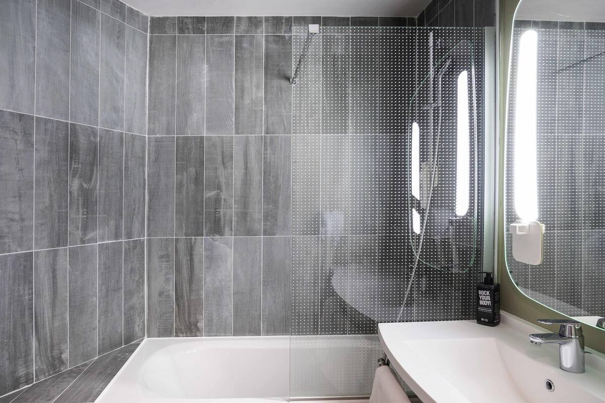 A modern bathroom with a bathtub, a sink, and a shower area.